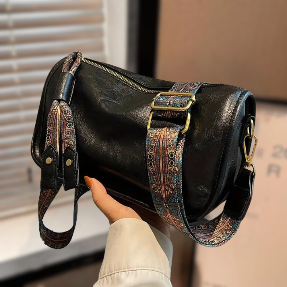 Women's stylish shoulder bag with a soft, textured finish, featuring a zippered closure and an adjustable patterned strap for a chic and versatile look.