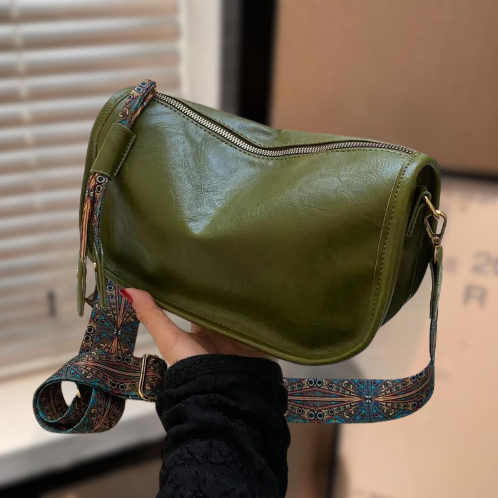 Women's stylish shoulder bag with a soft, textured finish, featuring a zippered closure and an adjustable patterned strap for a chic and versatile look.